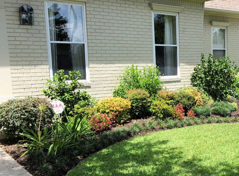 garden installation with some bushes outside of a beige house